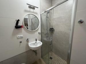 a bathroom with a shower and a sink and a mirror at Siesta apartment on Stefanyka in Lviv +21 photos