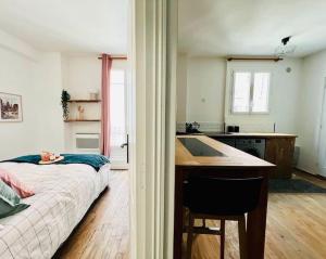 ein Schlafzimmer mit Bett und eine Küche mit Spüle in der Unterkunft Joli Appartement à 15min des Champs Elysée in Saint-Ouen
