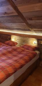 Ce lit se trouve dans un dortoir doté d'un plafond en bois. dans l'établissement Chalet le Grenier - Romantique et exclusif, à Champéry