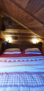 a bed in a wooden room with two pillows on it at Chalet le Grenier - Romantique et exclusif in Champéry