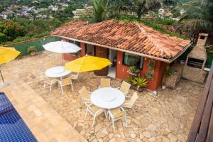 a patio with tables and chairs and umbrellas at Pousada Bella Vista Geribá in Búzios