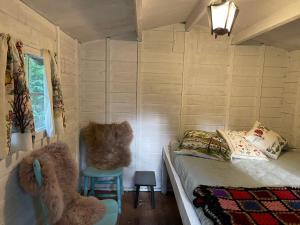 Habitación pequeña con cama y silla en Little Chez Louis en tipitent, en Papenvoort