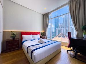 1 dormitorio con cama, escritorio y ventana grande en Soho Suites klcc by i.desk, en Kuala Lumpur