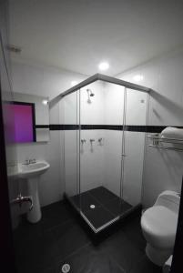 a bathroom with a shower and a toilet and a sink at HOTEL ZAFIRO PLAZA in Tunja