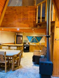 uma cozinha e sala de estar com um fogão numa cabina em Domos Hijos del Bosque em Coñaripe