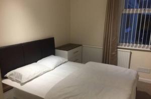 a bedroom with a white bed and a window at Duncan House in Leicester