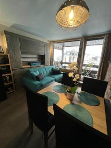 salon ze stołem i zieloną kanapą w obiekcie Appt 123 Home Club Tignes w mieście Tignes