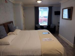 een slaapkamer met een groot wit bed in een kamer bij 29 Well Street B&B in Moffat