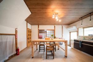 宇和島市にあるDear Uうわじまゲストハウス＆カフェのキッチン、ダイニングルーム(木製のテーブルと椅子付)