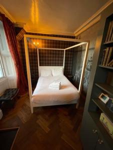 a small bedroom with a bed with a canopy at JOIVY Luxury Old Town Apartment in Edinburgh