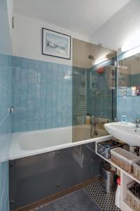 a bathroom with a shower and a sink and a tub at L'Edelweiss - Au pied des pistes in Enchastrayes