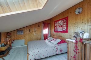 a bedroom with a bed and a wooden wall at L'Edelweiss - Au pied des pistes in Enchastrayes