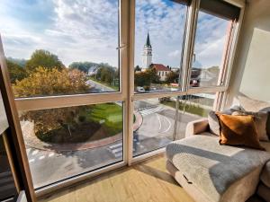 a living room with a window view of a church at Miadora apartments - Apartma Rusalka in Moravske-Toplice