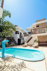 a villa with a swimming pool in front of a house at Apartamento Manay in Jericoacoara