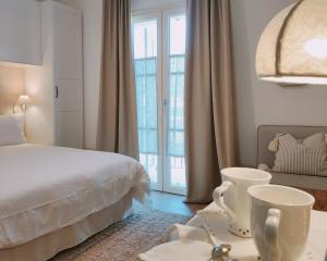 a white bedroom with a bed and a window at Il Cortiletto - Suites & Apartments in Pistoia