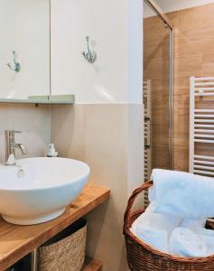 ein Badezimmer mit einem weißen Waschbecken und einer Glasdusche in der Unterkunft Il Cortiletto - Suites & Apartments in Pistoia