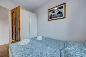 シュチェチンにあるAleda Galaxyのベッドルーム1室(ベッド1台付)が備わります。壁に絵が飾られています。