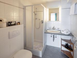 a bathroom with a shower and a toilet and a sink at Hotel Regina in Serfaus