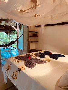 a bedroom with a bed with towels on it at CASA AITI, ex-Casa da Cris e Paulo in Ilha de Boipeba