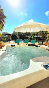 a large swimming pool with an umbrella and chairs at Place in the sun - Free out door Jacuzzi - BY BEDZY in Albufeira