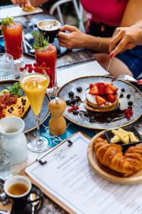 a table topped with plates of food and drinks at Aria Hotel Budapest by Library Hotel Collection in Budapest