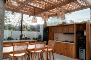 a kitchen with wooden cabinets and a table and chairs at Sanjula Uluwatu in Uluwatu