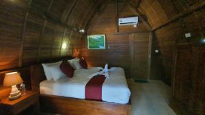 una camera da letto con letto in una camera in legno di Kelingking Tatakan Bungalow a Nusa Penida