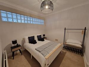 Un dormitorio con una cama grande y una ventana en Lovely Seafront Apartment with Garden, en Swansea