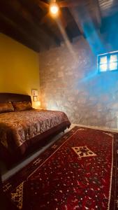 ein Schlafzimmer mit einem Bett mit einer Steinmauer in der Unterkunft Castillo De La Santa Cruz in Guanajuato