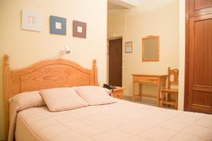 sypialnia z dużym łóżkiem i biurkiem w obiekcie Hostal Sierpes w Sewilli