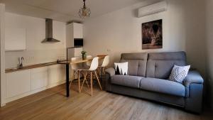 sala de estar con sofá azul y cocina en Parador 10 Apartamentos, en Cehegín