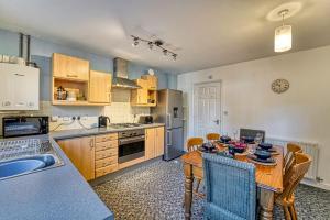 a kitchen with a wooden table and a dining room at Guest Homes - Lion Court in Worcester