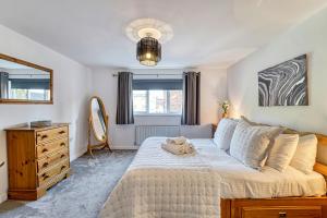 um quarto com uma cama grande, uma cómoda e um espelho. em Guest Homes - Lion Court em Worcester