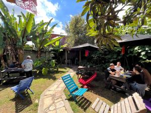 a group of people sitting at a table in a garden at The Coffee Bean Hostel in San Cristóbal de Las Casas