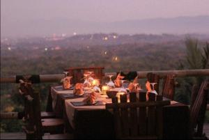 a table with candles on it with a view at Rajaklana Resort and Spa in Bantul