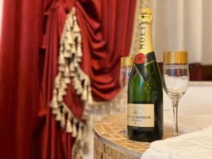 una botella de champán y una copa de vino en una mesa en Vila Imperial One Luxury Boutique Hotel en Făgăraş