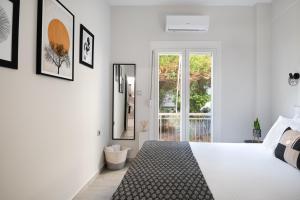a white bedroom with a bed and pictures on the wall at apt Eleven - cozy apartment with garden in Athens