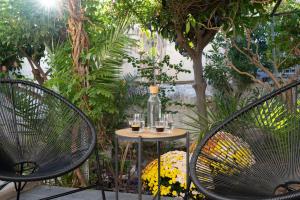 two chairs and a table with glasses of wine at apt Eleven - cozy apartment with garden in Athens
