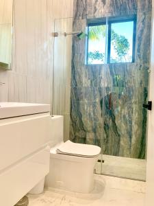 a white bathroom with a toilet and a shower at Men only clothing option guesthouse near Wilton Manors in Fort Lauderdale
