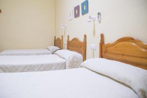 Łóżko lub łóżka w pokoju w obiekcie Hostal Sierpes