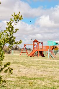 an empty playground in a field with a tree at La Chakana de Uribelarrea in Uribelarrea