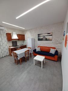 ein Wohnzimmer mit einem Sofa und einem Tisch in der Unterkunft Casa Emilia in Ragusa