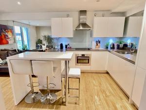 a kitchen with white cabinets and a white counter top at Westminster-Gem in London