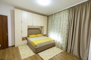 Habitación pequeña con cama y ventana en Tirana Contact Apartment en Tirana