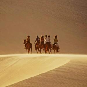 un grupo de gente montando caballos en el desierto en Tatadise, en Tatajuba
