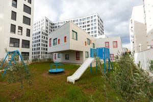 um parque infantil com um escorrega em frente a um edifício em Tirana Contact Apartment em Tirana