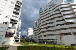 dos edificios altos están uno al lado del otro en Tirana Contact Apartment en Tirana