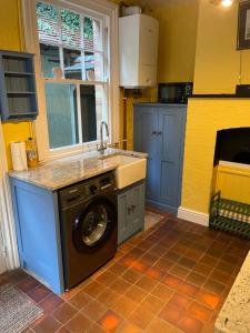 a kitchen with a washing machine and a sink at Spring View in Little Malvern