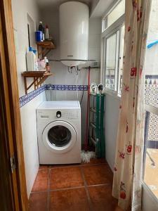 een wasmachine in een kleine badkamer met een raam bij Casa del Aceite de Oliva Virgen Extra in Jaén