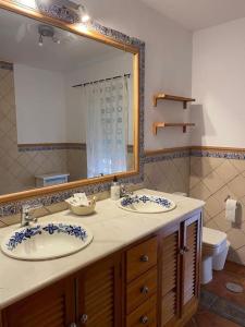 uma casa de banho com 2 lavatórios e um espelho grande em Casa del Aceite de Oliva Virgen Extra em Jaén